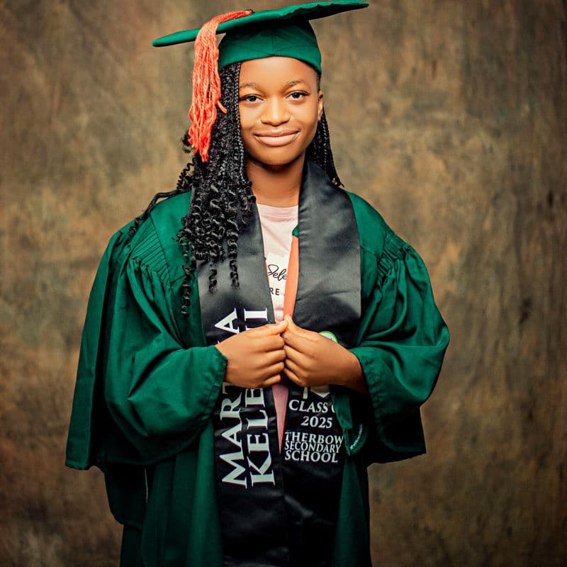 A smiling graduate in cap and gown