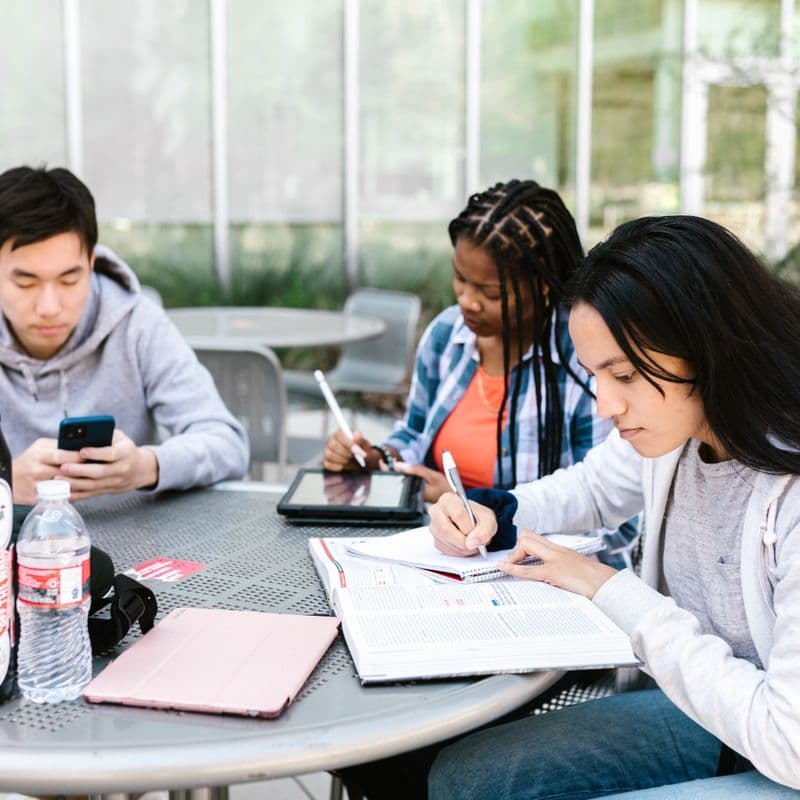 Students studying together at a table with books and notes